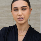 Woman in black shirt standing against a neutral background
