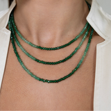 Green gemstone necklace on model with three layers